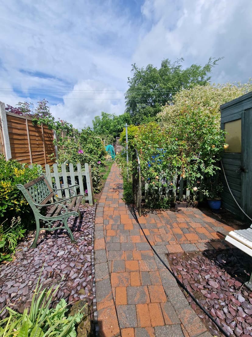 Garden block path after — crisp and clean under a blue sky.