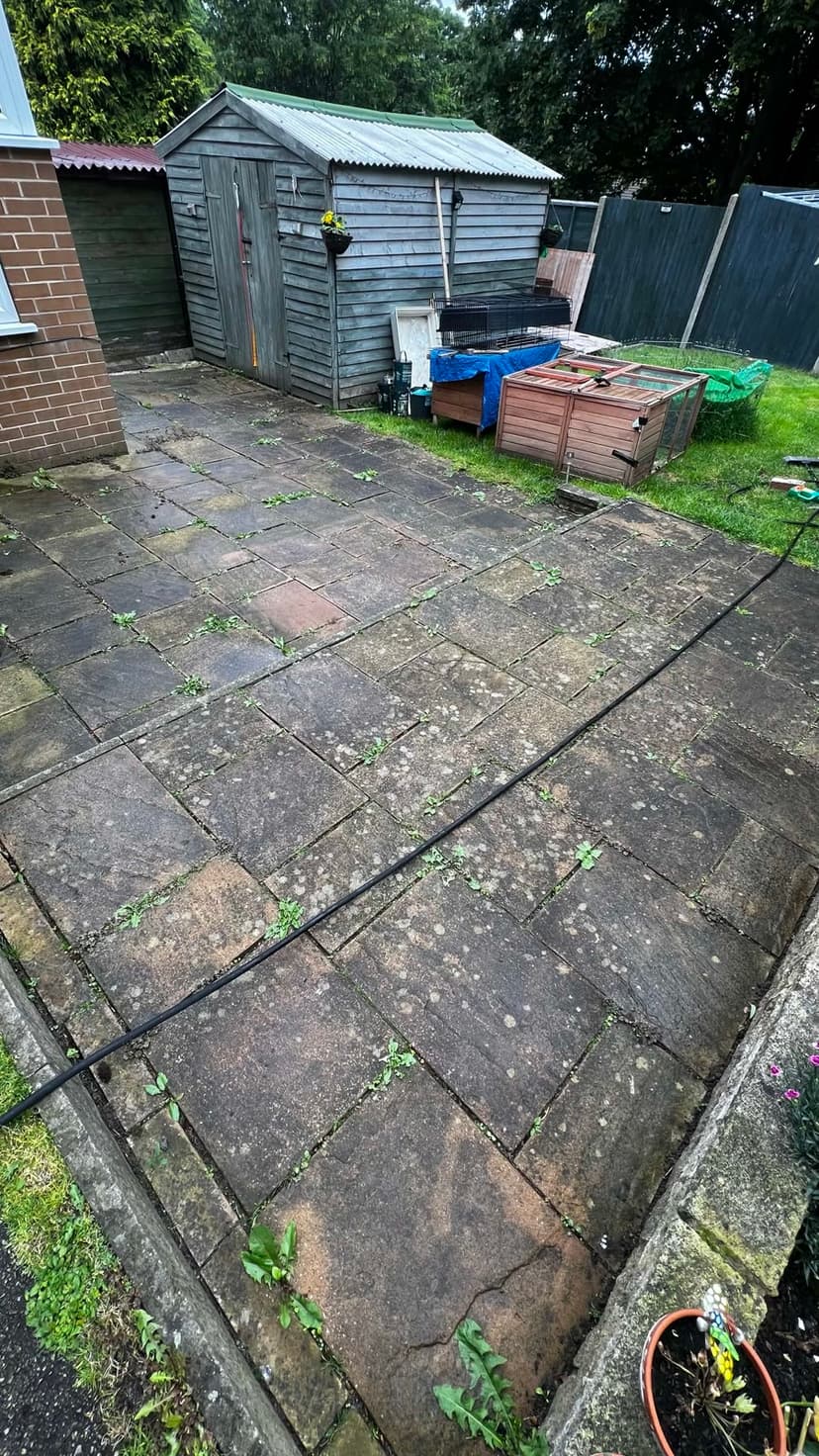 Before — the same concrete patio greened-over and tired.