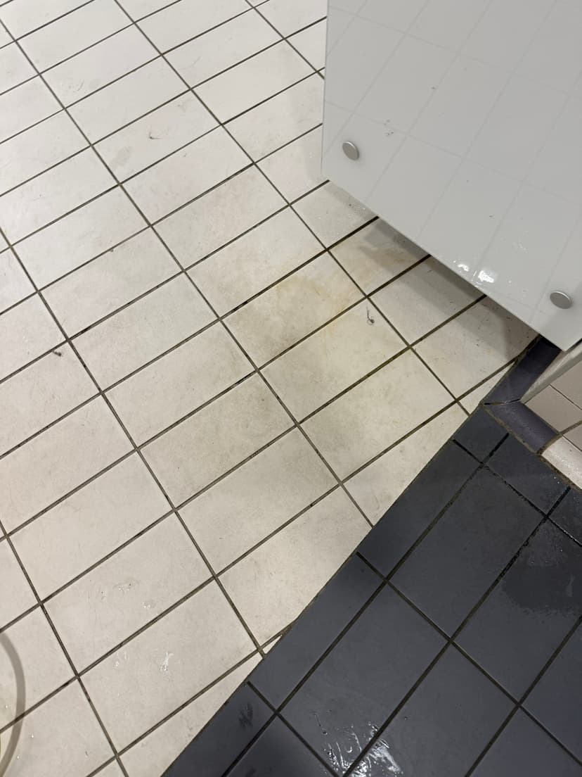 Changing-village floor mid-clean — staining lifting pass by pass.